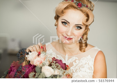 Beautiful bride wearing fashion wedding dress with feathers with luxury delight make-up and Beautiful bride wearing fashion wedding dress with feathers with luxury delight make-up and 58376944