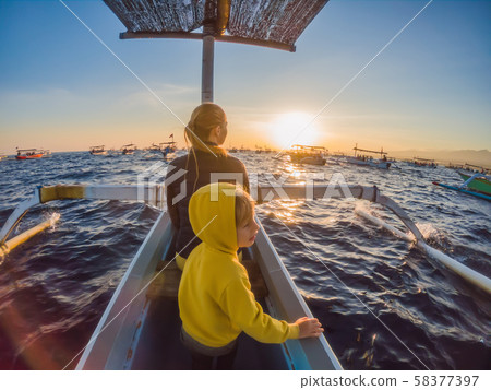 Mother and son travelers meets dawn in the sea on a boat 58377397