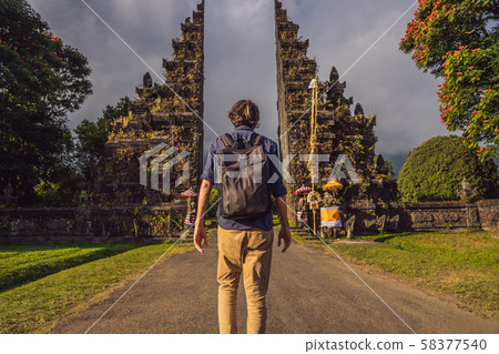 Tourist man walking through Traditional Balinese Hindu gate Candi Bentar close to Bedugul, Bratan Tourist man walking through Traditional Balinese Hindu gate Candi Bentar close to Bedugul, Bratan 58377540