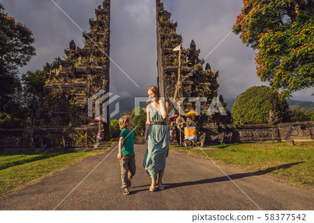 Mother and son walking through Traditional Balinese Hindu gate Candi Bentar close to Bedugul, Bratan Mother and son walking through Traditional Balinese Hindu gate Candi Bentar close to Bedugul, Bratan 58377542