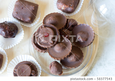 Homemade raw chocolate sweet candies with raspberries inside with droplets of water and raspberry 58377543
