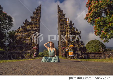 Tourist woman walking through Traditional Balinese Hindu gate Candi Bentar close to Bedugul, Bratan Tourist woman walking through Traditional Balinese Hindu gate Candi Bentar close to Bedugul, Bratan 58377576