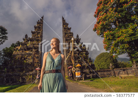 Tourist woman walking through Traditional Balinese Hindu gate Candi Bentar close to Bedugul, Bratan 58377577