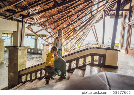 mother and son tourists in abandoned and mysterious hotel in Bedugul. Indonesia, Bali Island. Bali mother and son tourists in abandoned and mysterious hotel in Bedugul. Indonesia, Bali Island. Bali 58377605