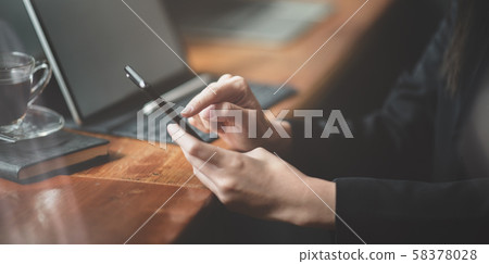 Businesswoman working on tablet while using 58378028