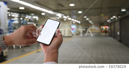 Man touching blank screen smartphone at railway 58378029