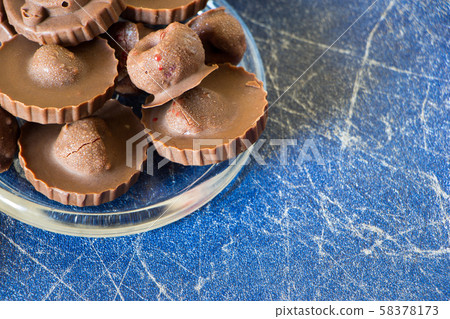 Homemade raw chocolate sweet candies with raspberries inside, Blue background with copy space Homemade raw chocolate sweet candies with raspberries inside, Blue background with copy space 58378173