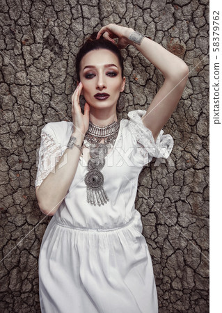 Portrait of a girl lying on a cracked, dry ground. 58379762