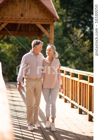 Caring husband hugging wife while walking at the weekend Caring husband hugging wife while walking at the weekend 58380050