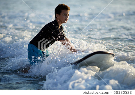 surfer battles the waves on a beautiful sunny day surfer battles the waves on a beautiful sunny day 58380528