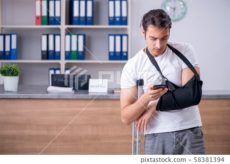 Young man at hospital reception desk Young man at hospital reception desk 58381394