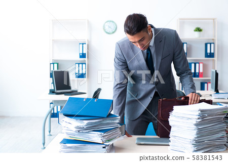 Businessman with heavy paperwork workload Businessman with heavy paperwork workload 58381543