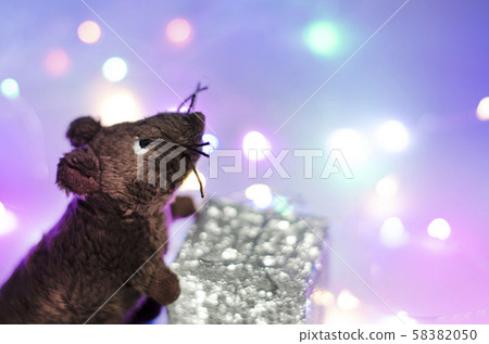 The toy mouse holds a gift. New Year 2020. The toy mouse holds a gift. New Year 2020. 58382050