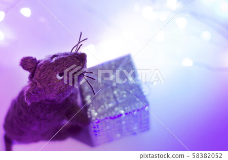 The toy mouse holds a gift. New Year 2020. The toy mouse holds a gift. New Year 2020. 58382052