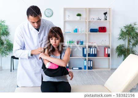 Young woman visiting male doctor traumatologist 58382156