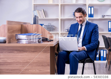 Young handsome businessman working in the office Young handsome businessman working in the office 58383108