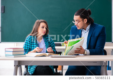 Young handsome teacher and female student in the classroom Young handsome teacher and female student in the classroom 58383111