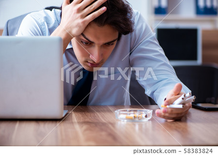 Male employee smoking cigarettes at workplace Male employee smoking cigarettes at workplace 58383824