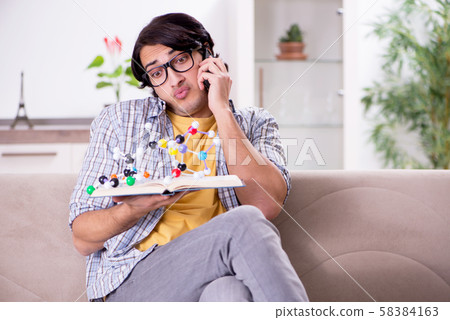 Young student physicist preparing for exam at home Young student physicist preparing for exam at home 58384163