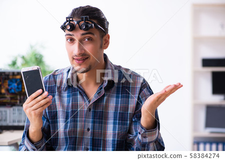 Young handsome technician repairing mobile phone Young handsome technician repairing mobile phone 58384274