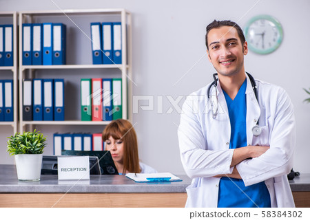Two doctors working at the reception in the hospital Two doctors working at the reception in the hospital 58384302