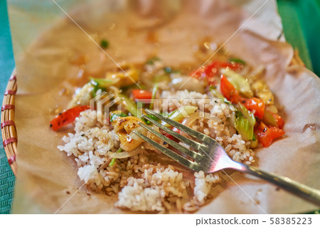 Fork, rice with vegetables on parchment in restaurant Fork, rice with vegetables on parchment in restaurant 58385223