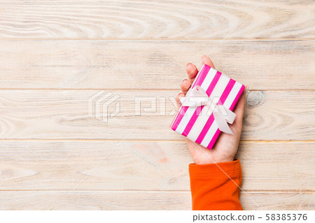 Girl Hands holding craft paper gift box with as a 58385376