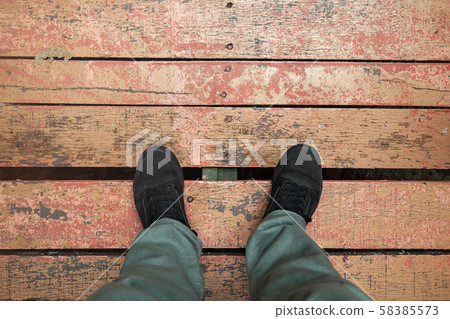 Male feet in sneakers stand on floor Male feet in sneakers stand on floor 58385573