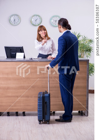 Young businessman at hotel reception Young businessman at hotel reception 58386387