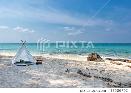 romantic white picnic tent on white sand beach with crystal clear water and blue sky at background 58386792