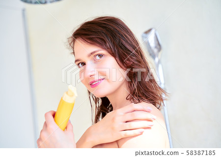 Photo of happy girl with body lotion in her hands . Photo of happy girl with body lotion in her hands . 58387185