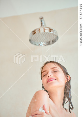 Photo of young woman taking shower . 58387355