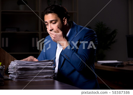 Young male employee working night in the office Young male employee working night in the office 58387386