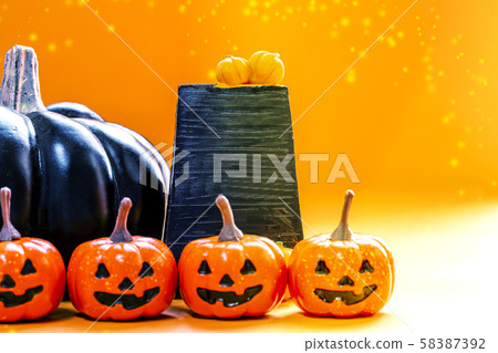 很多小橙色南瓜和大黑南瓜和黑色站立的跡象 58387392