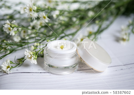 cosmetic nature skincare concept. organic natural beauty product. alternative medicine made from herbal. white cream serum in mock up packaging with blank label decorate with white flower 58387602