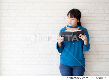 Beautiful of portrait young asian woman happiness relax standing reading book 58388094