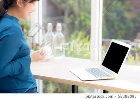 Beautiful portrait asian young freelance woman working online laptop with smile and happy 58388095