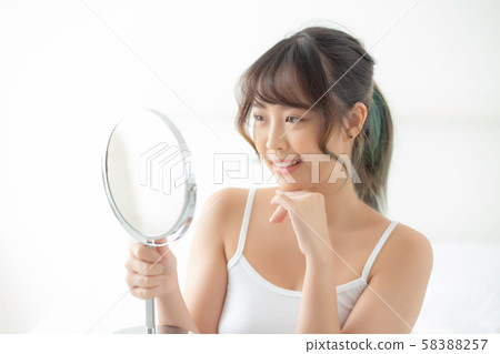 Beautiful face young asian woman with happy smiling and looking mirror Beautiful face young asian woman with happy smiling and looking mirror 58388257