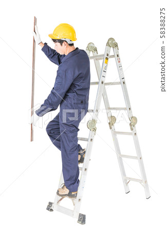 Handyman in uniform standing on ladder holding Handyman in uniform standing on ladder holding 58388275