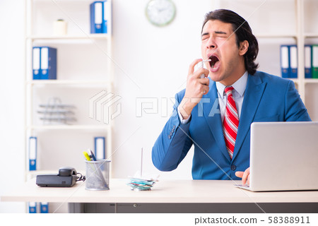 Young male employee suffering in the office Young male employee suffering in the office 58388911