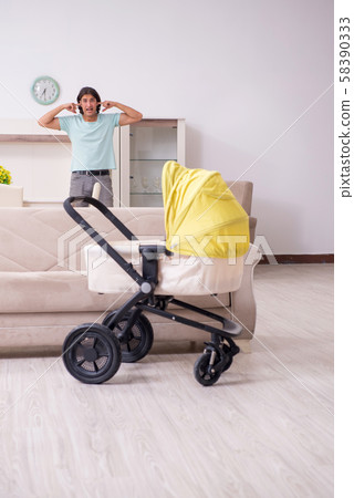 Young man looking after baby in pram 58390333