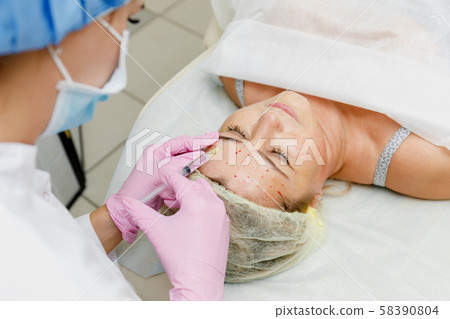 Beautician doing facial injection 58390804