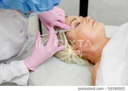 Beautician doing facial injection Beautician doing facial injection 58390805