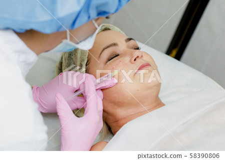 Beautician doing facial injection Beautician doing facial injection 58390806