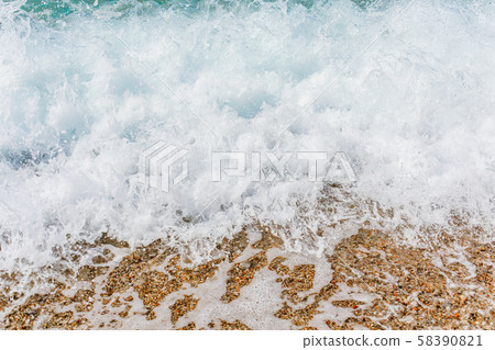 Turquoise sea waves splashing on pebble shore Turquoise sea waves splashing on pebble shore 58390821