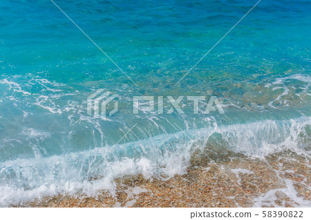 Turquoise sea waves splashing on pebble shore Turquoise sea waves splashing on pebble shore 58390822