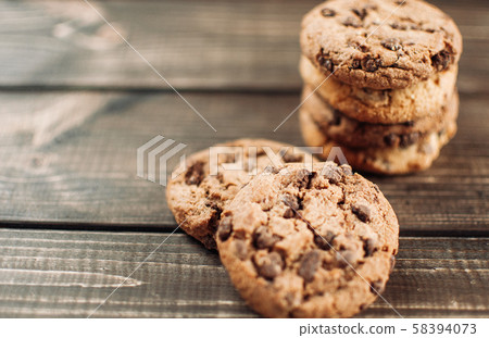 A stack of chocolate chip cookies lies on a wooden table. Rustic table. Vintage toning. Dietary A stack of chocolate chip cookies lies on a wooden table. Rustic table. Vintage toning. Dietary 58394073