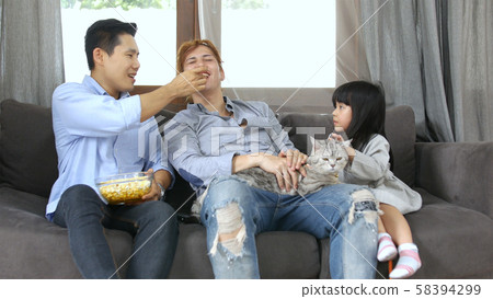 Family concept. The girl is playing a cat with her Family concept. The girl is playing a cat with her 58394299