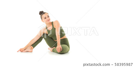 A beautiful young female gymnast with dark long hair stuffed into a bundle in a green sports elastic A beautiful young female gymnast with dark long hair stuffed into a bundle in a green sports elastic 58395987