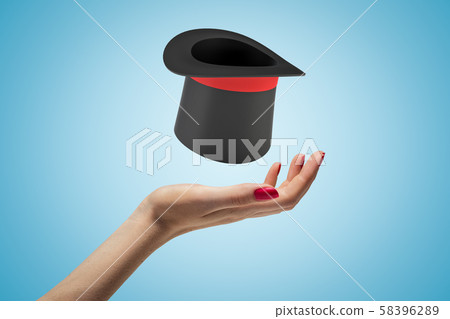 Female hand with black top hat above on blue background 58396289